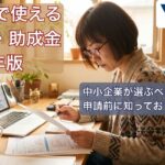 補助金の書類とノートPCを前に検討する中小企業経営者